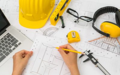 hand-over-construction-plans-with-yellow-helmet-and-drawing-tool_1232-2909